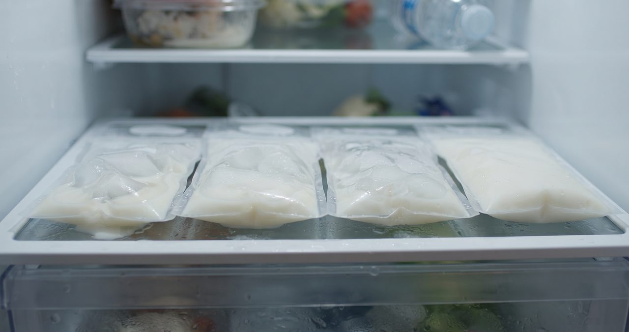 冷蔵庫の棚に並べて置かれた冷凍母乳の保存パックが、ゆっくり解凍されている様子